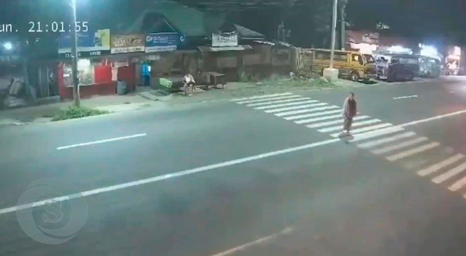 La mujer intentando cruzar una avenida muy transitada